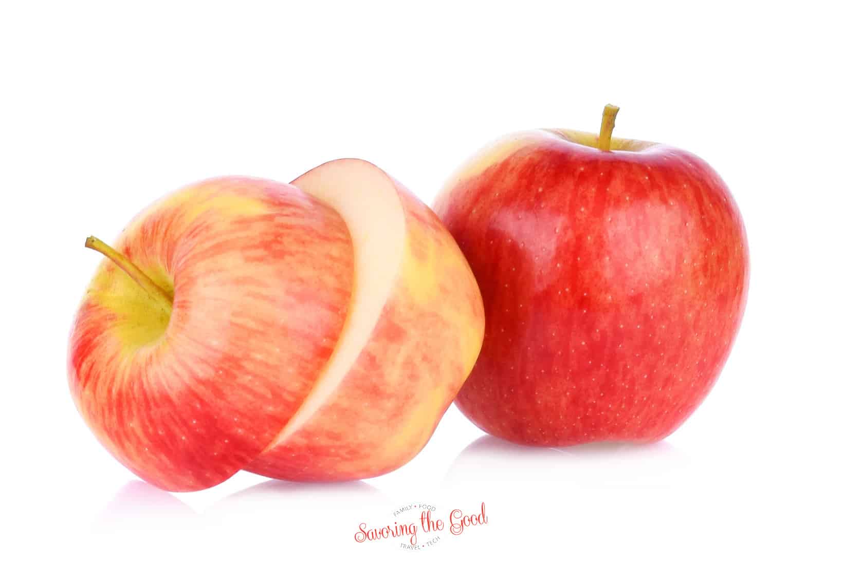 Two pink lady apples on a white background.one of the sliced in half horizontal.