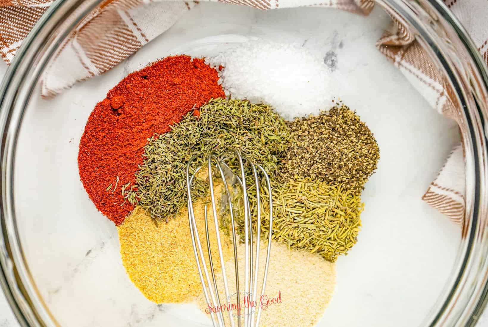 Spices in a bowl with a whisk.