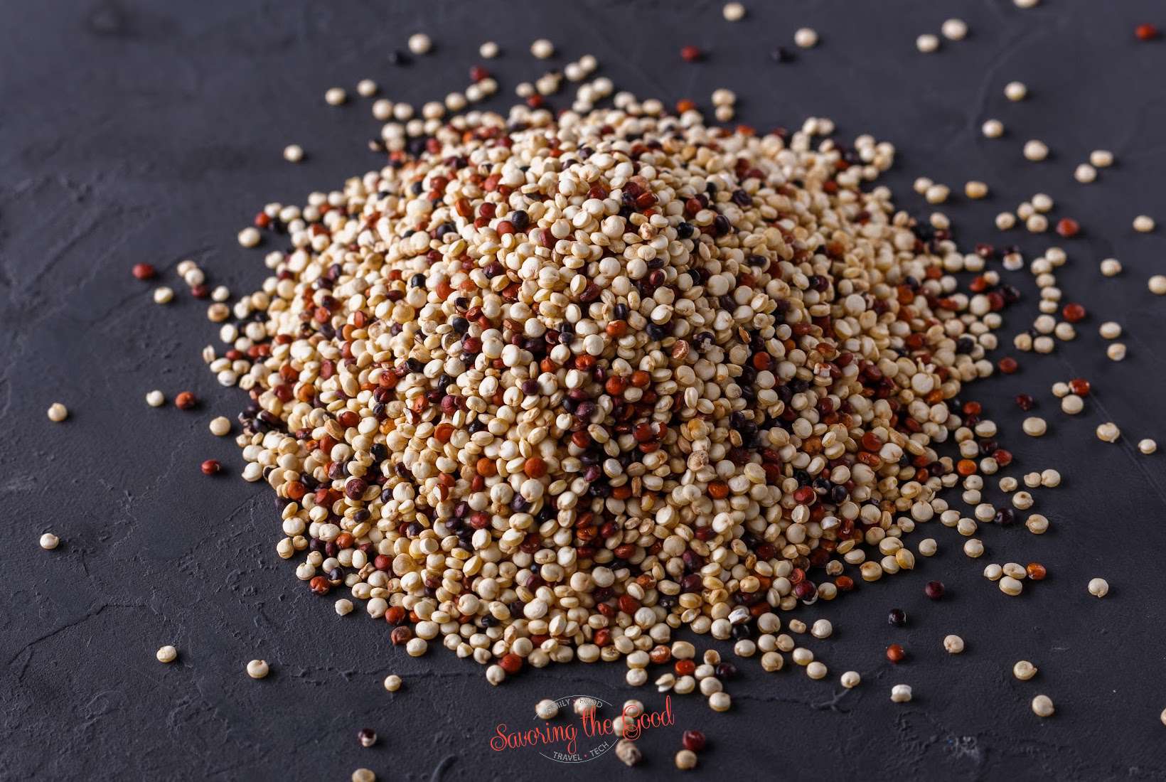 A pile of quinoa on a dark surface.