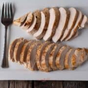 sous vide chicken breasts sliced and fanned out on a white platter