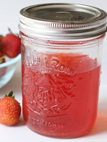 square image of a quart canning jar of homemade strawberry vodka