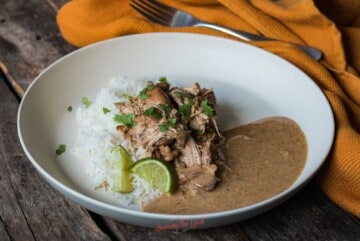 horizontal image of cilantro lime chicken on a bed of rice with sauce