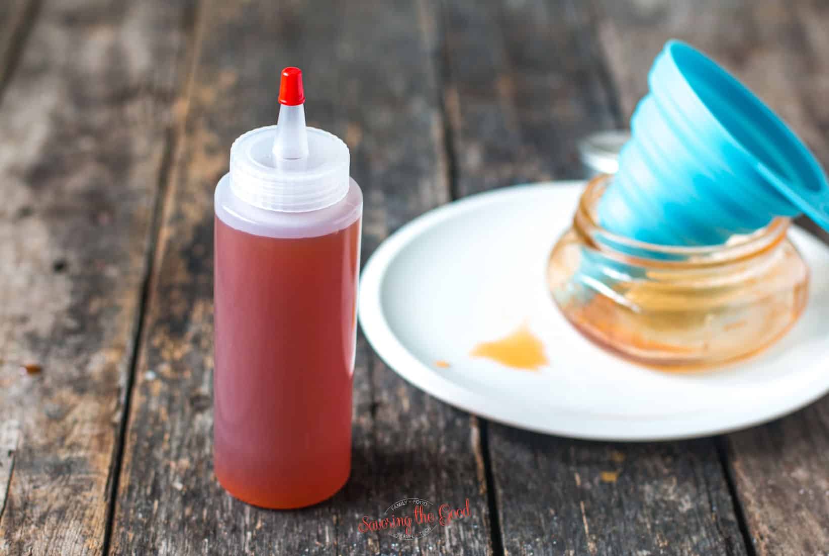 Hot Honey in a plastic squeeze bottle with funnel in the background