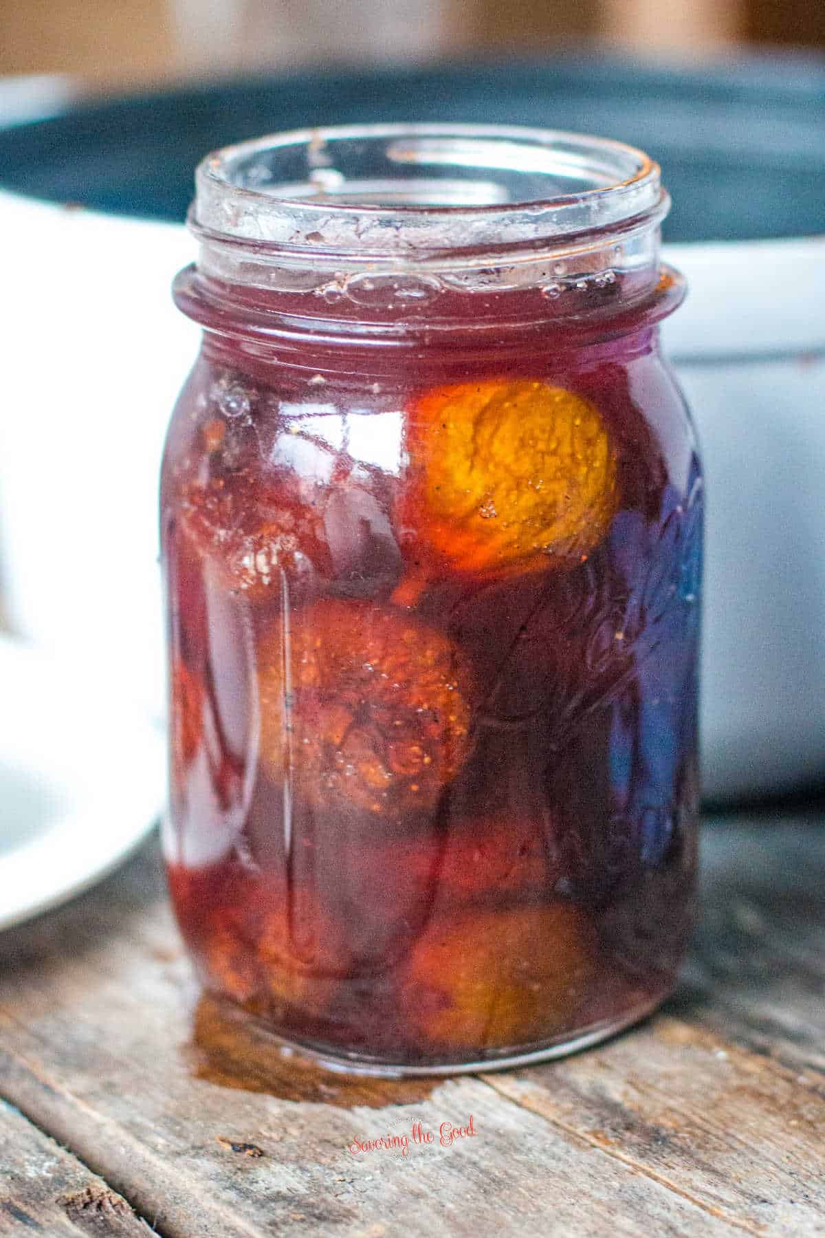 canning jar filled with preserved figs and poachin liquid