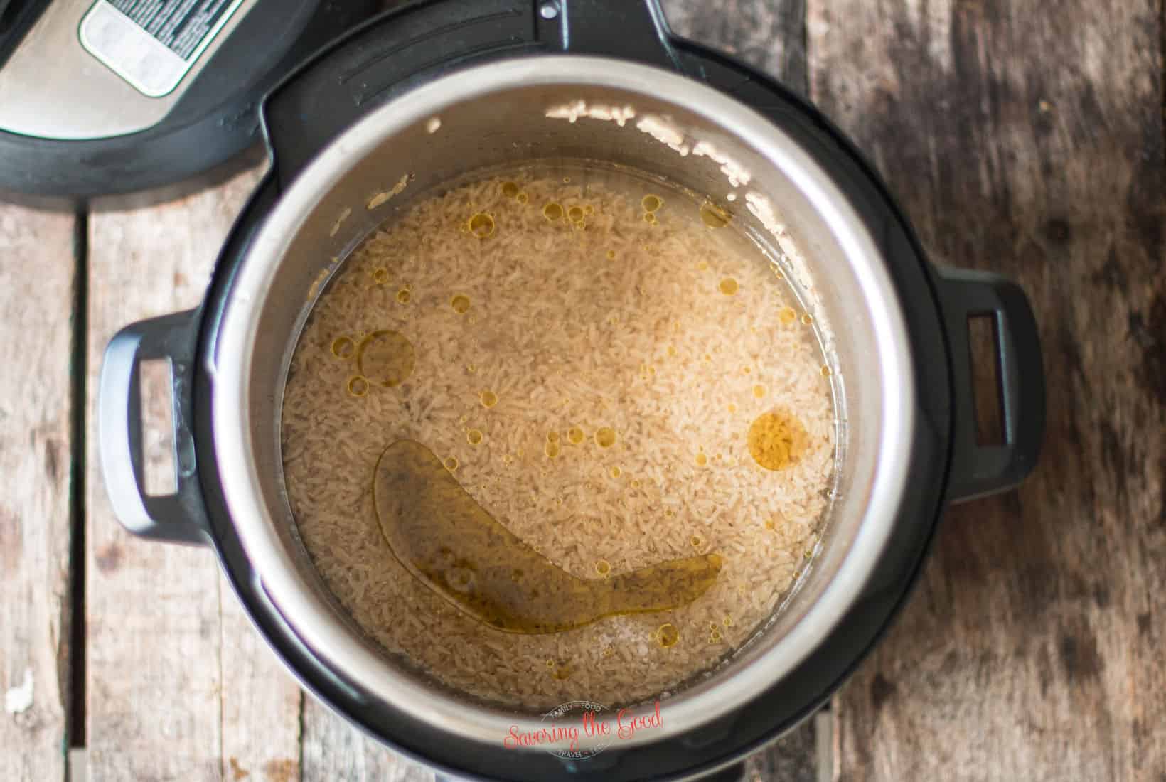 top down image of brown rice, water, olive oil and salt in an instant pot.