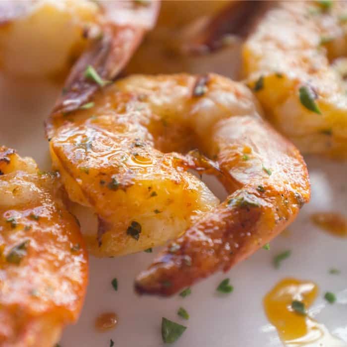 Indulge in a mouthwatering keto shrimp recipe featuring delicious grilled shrimp plated elegantly on a white dish.