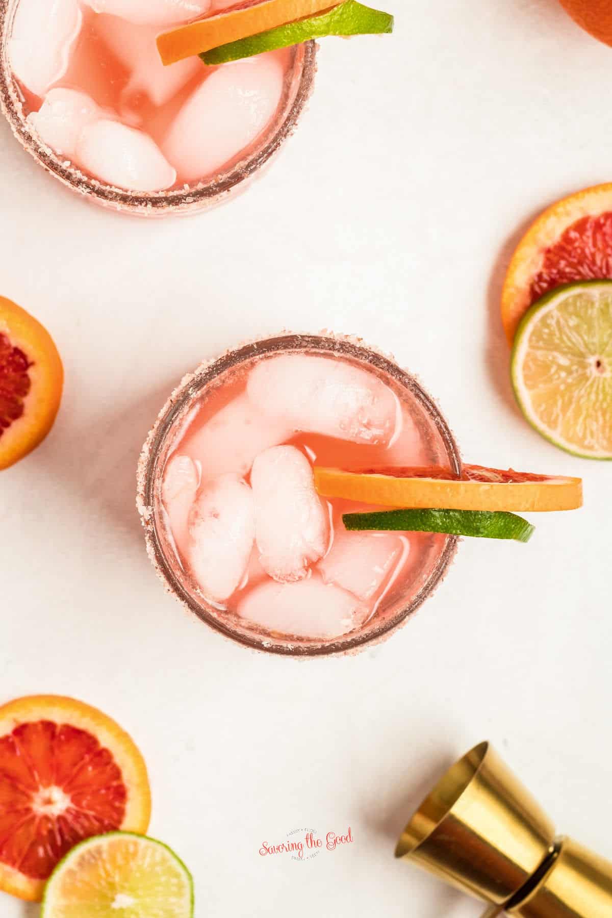 top down image of glasses of Blood Orange Margaritas on a white table.