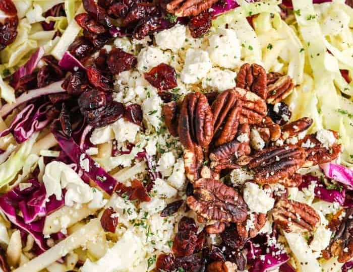 A bowl of slaw with pecans and cranberries.