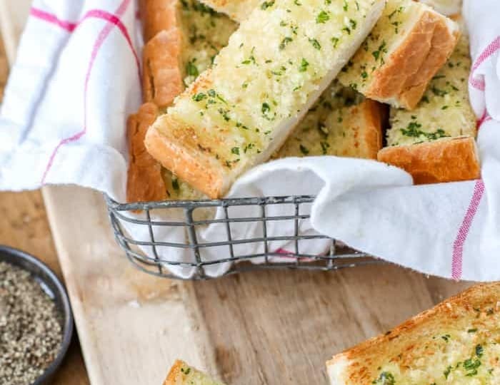 Sliced bread with herbs on a cutting board, perfect for beef stroganoff side dishes.