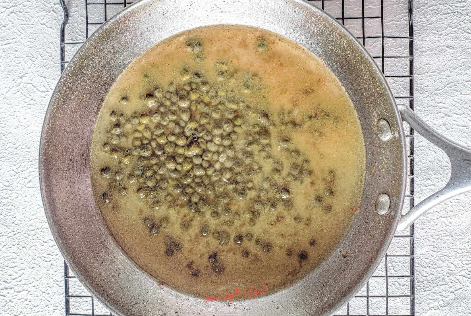 capers and chicken stock and lemon juice added to the pan to make chicken piccata sauce.