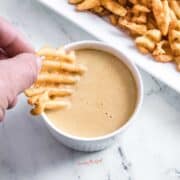 chick fil a sauce, copycat,in a white ramekin, waffle fry being dipped into the sauce.