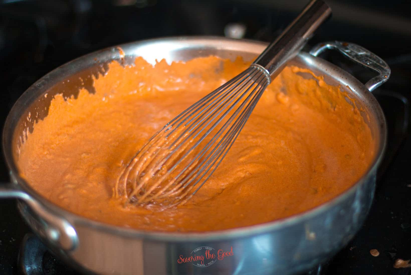 gigi hadid pasta sauce, in a pan with a whisk.