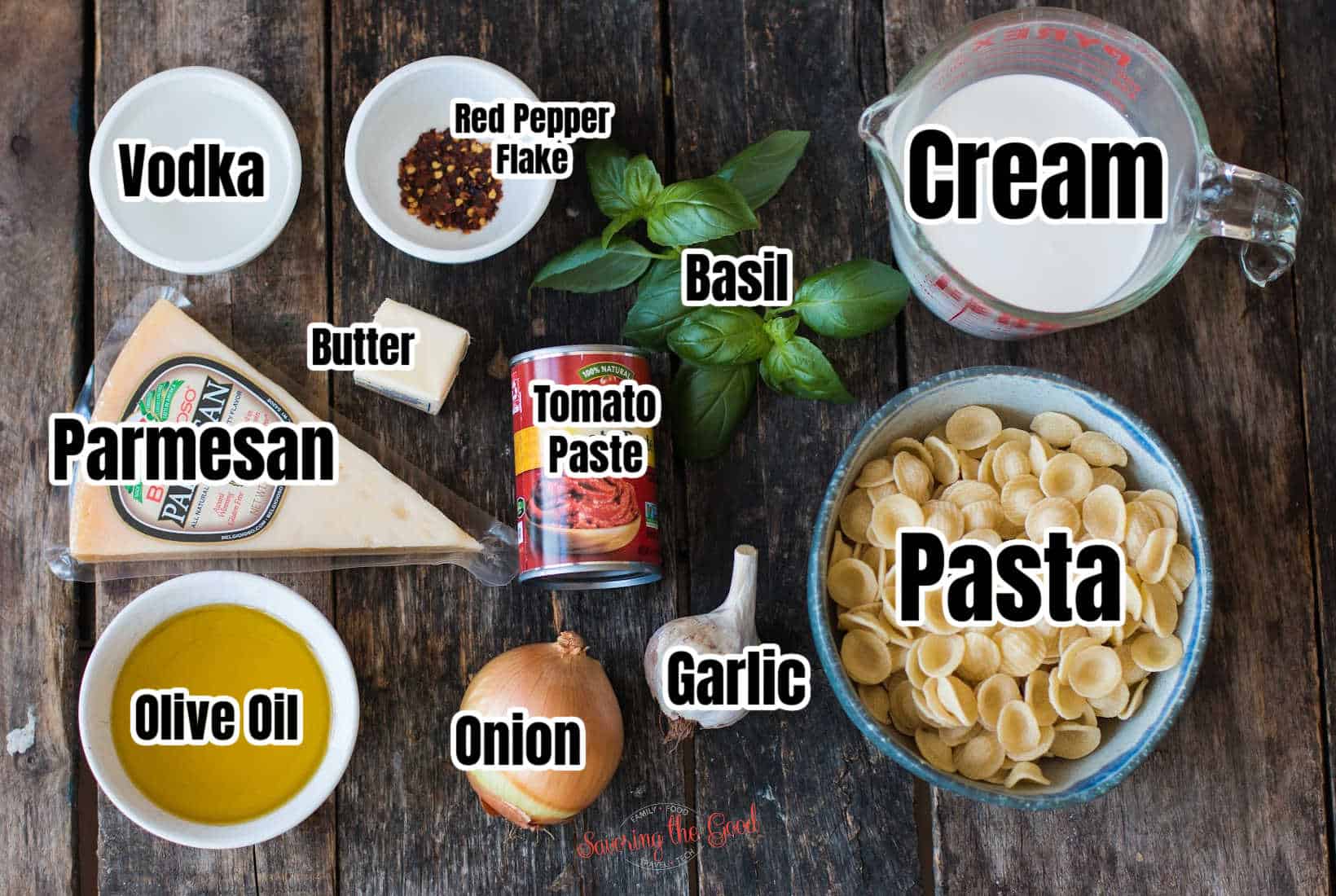 ingredients for gigi hadid pasta with text overlay labeling them. Vodka, red pepper flake, basil, cream, pasta, garlic, onion, tomato paste, butter, parmesan, olive oil.