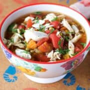 maryland crab soup with lump crab meat, carrot, broth, tomatoes, peppers in a bowl.