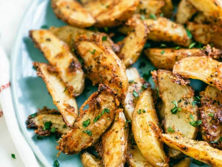 Roasted potato wedges on a blue plate.