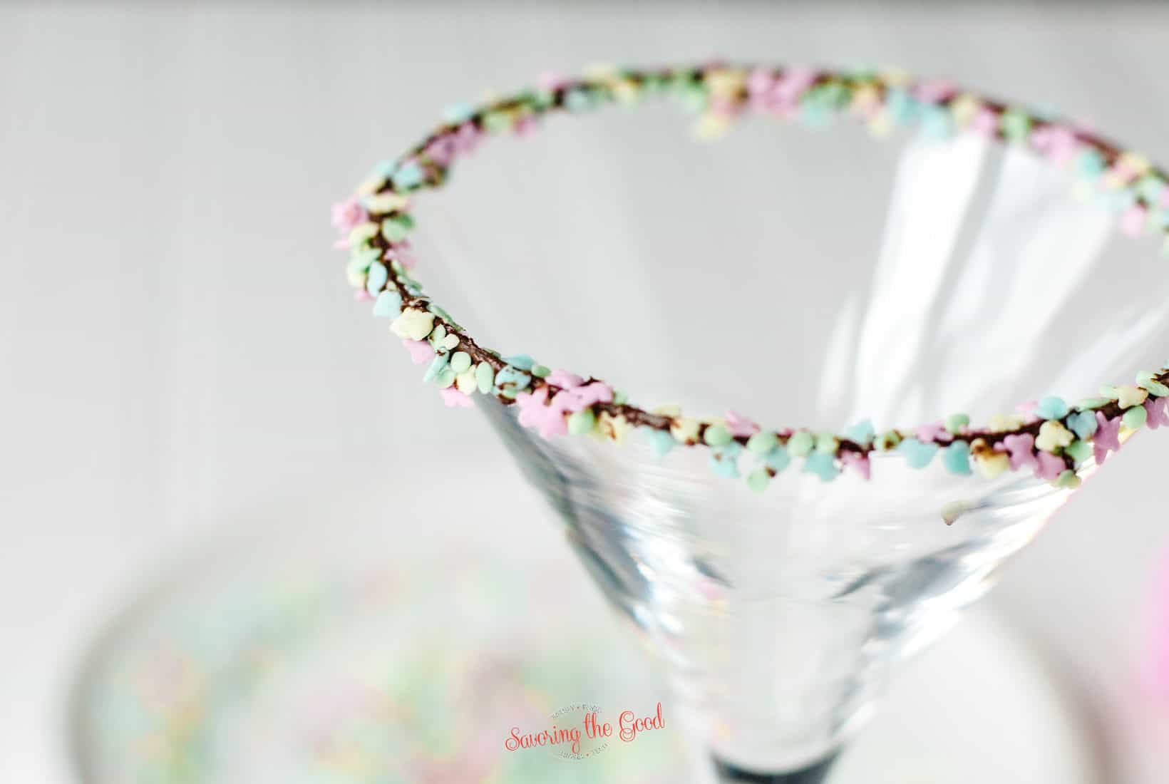 tight shot of a rim of the easter cocktail glass garnished with chocolate and easter sprinikles.