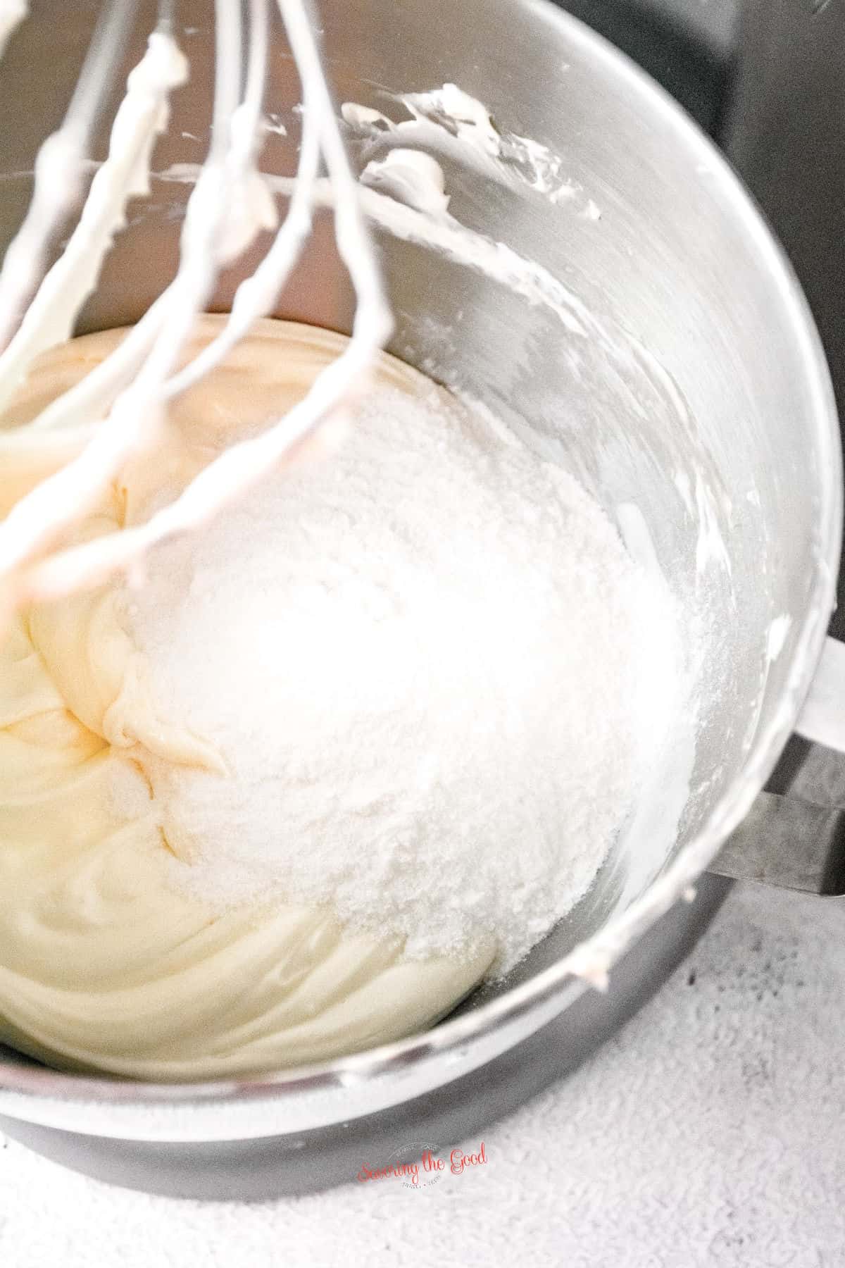 cheesecake ingredients being whipped in a stand mixer.