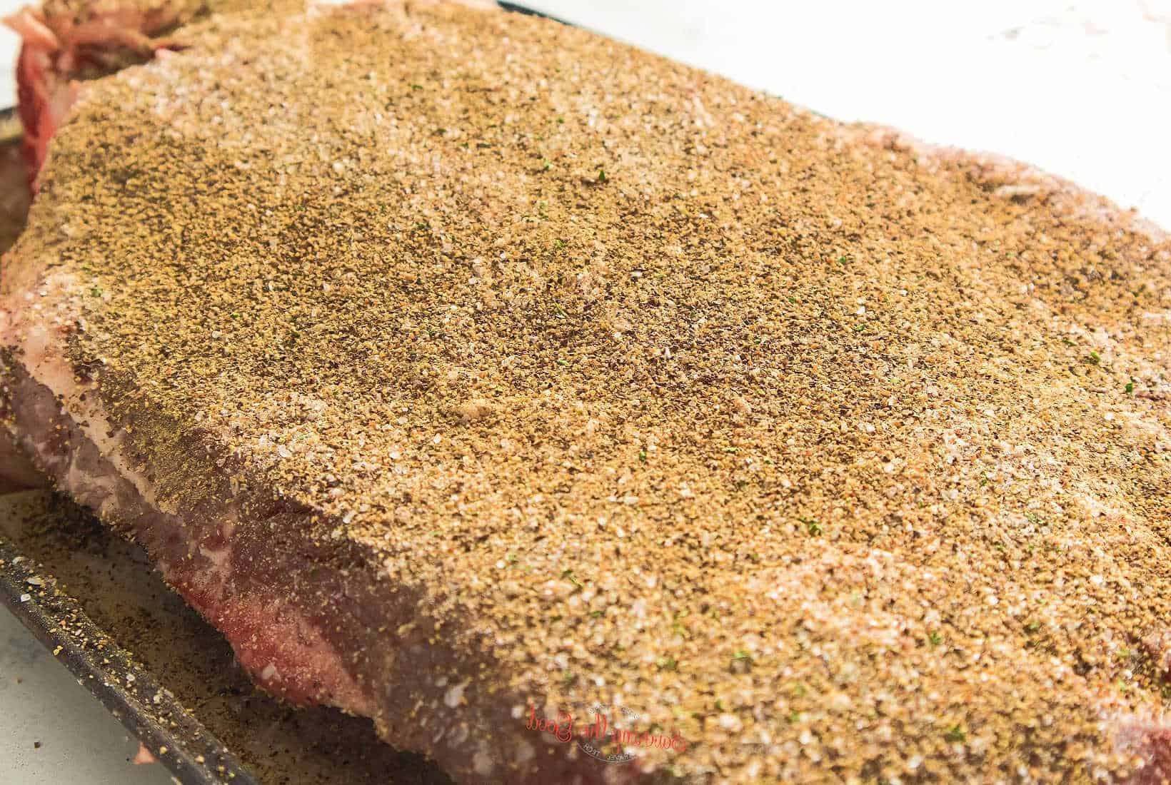spice rubbed brisket for smoking. no meat showing.