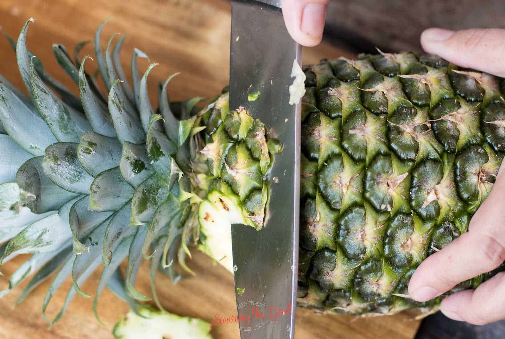 chef knife showing how to jut the shoulder off of a pineapple.