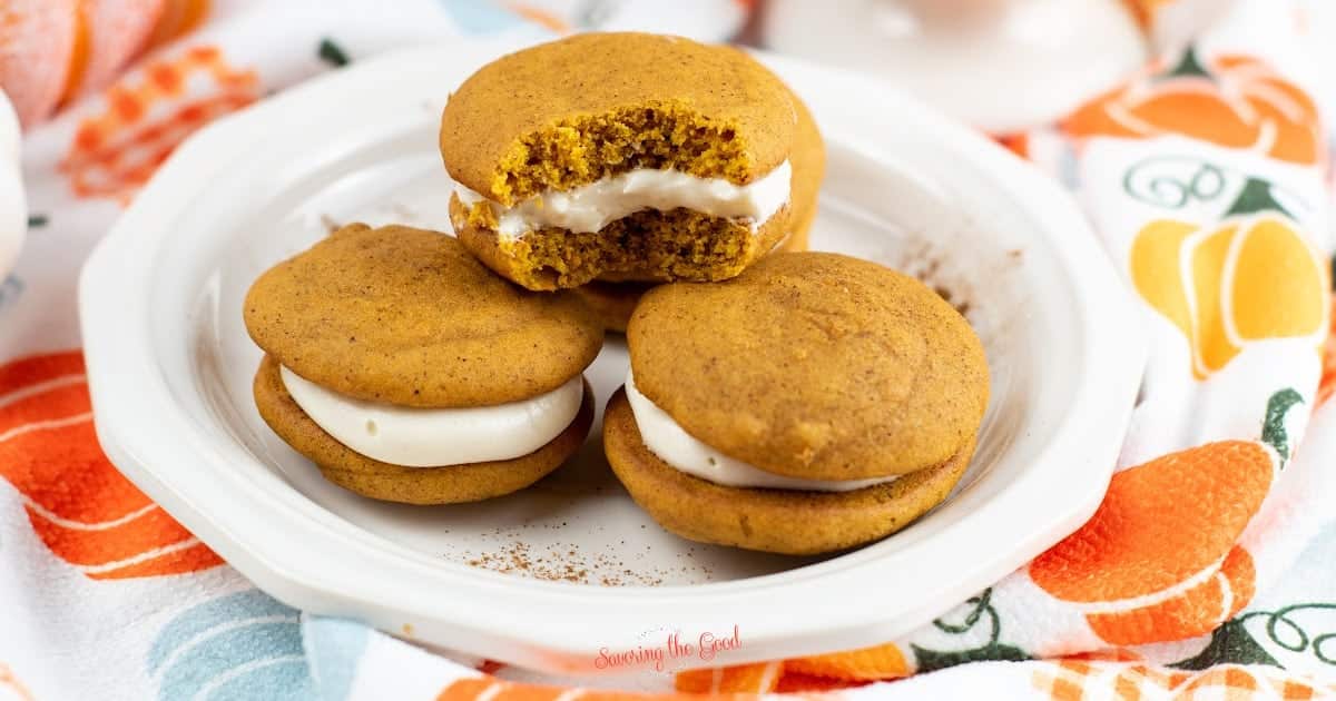Facebook horizontal pumpkin whoppie pies on a plate, one bite taken out.