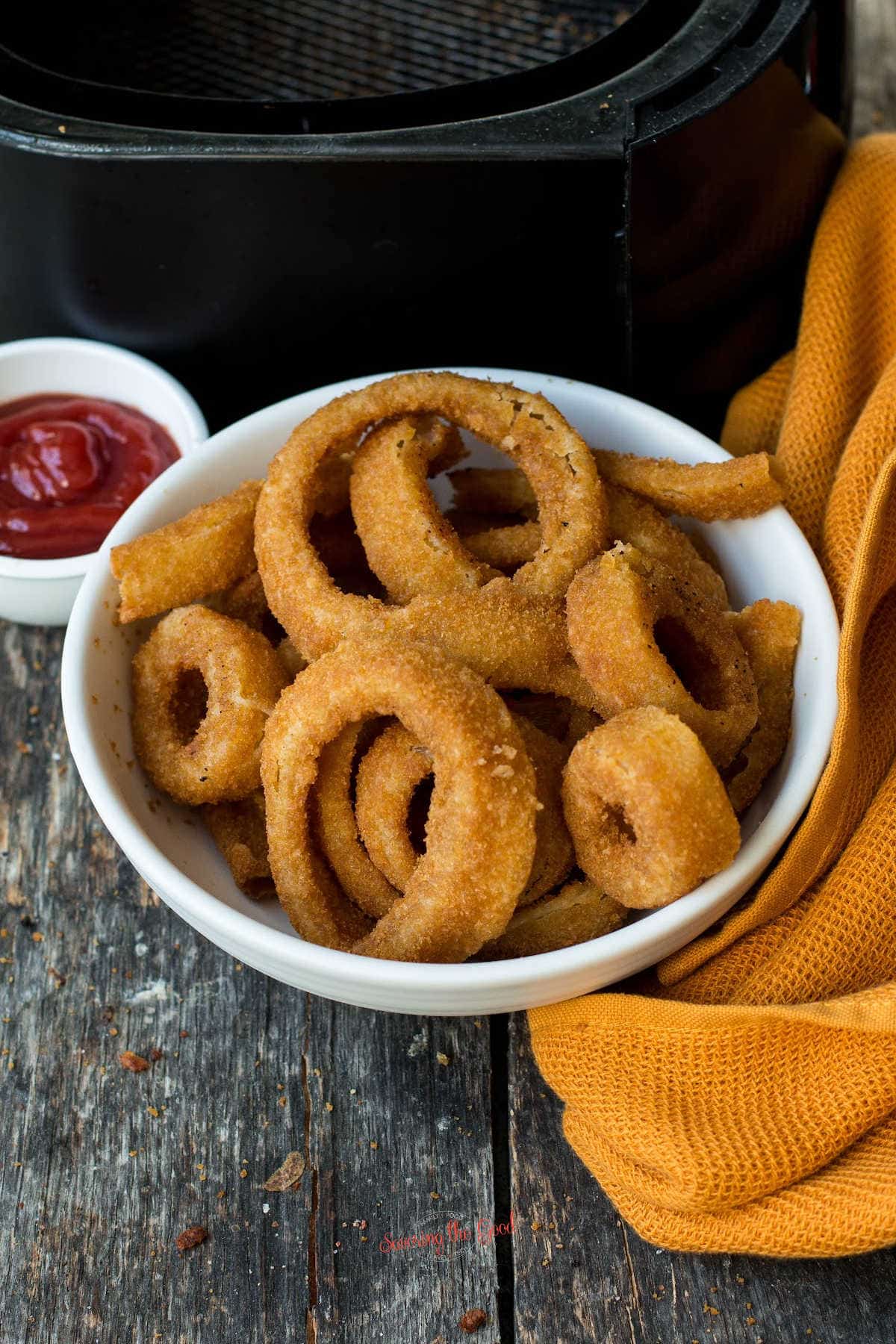 air fried onion rings in a white bowl.