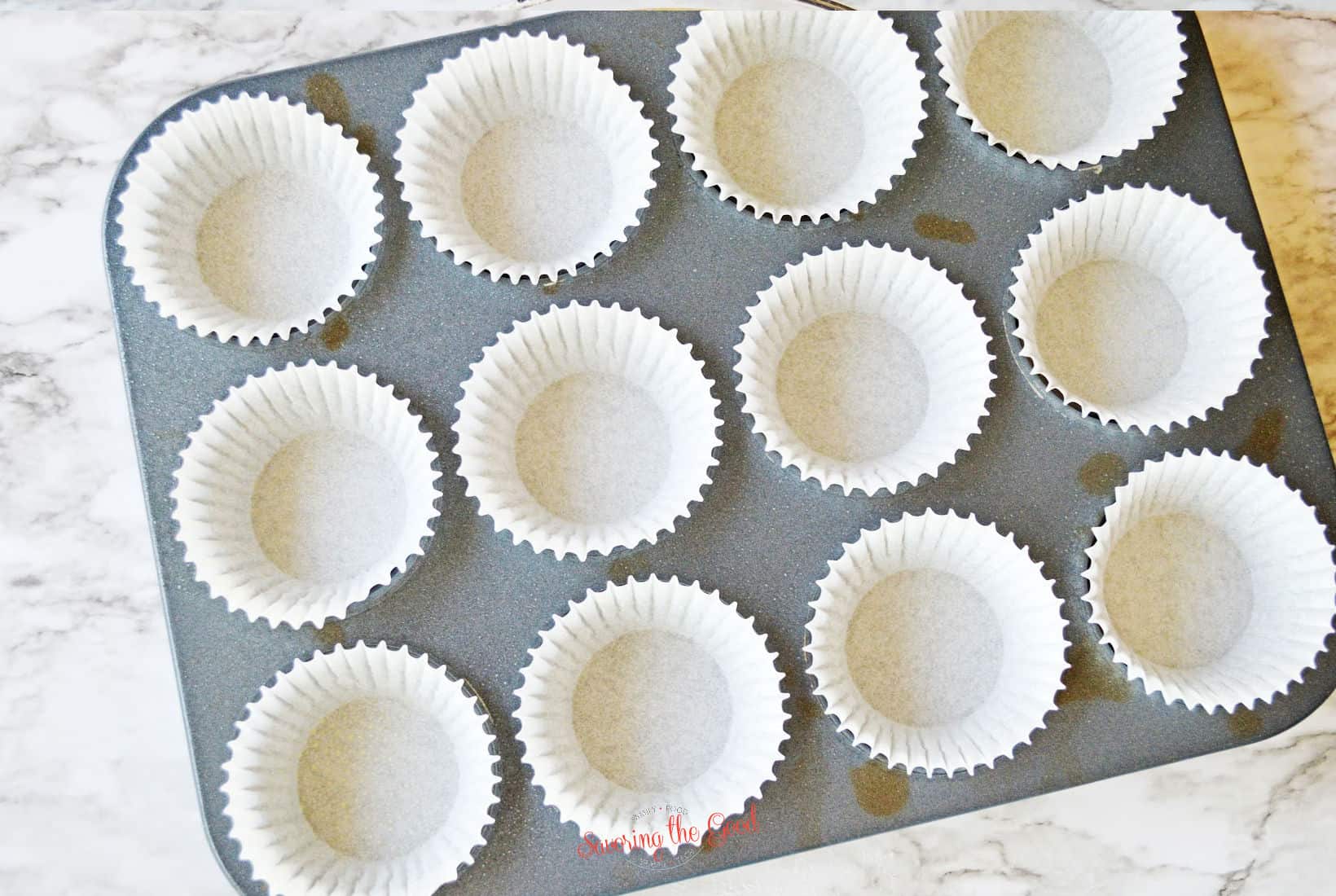 muffin tin with white muffin cups.