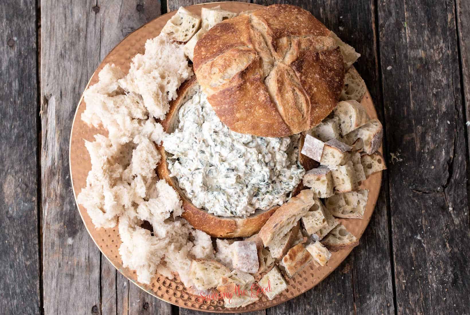 Knorr Spinach Dip in a bread bowl on a copper charger plate.