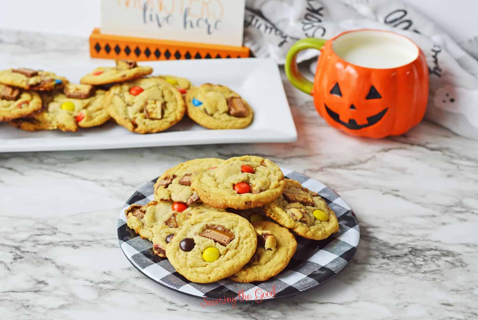 horizontal image of halloween candy cookies with halloween accessories in the background.