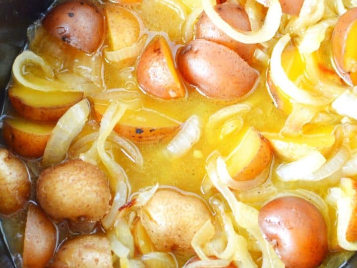 Discover one of the best baby potatoes recipes with this slow cooker dish featuring halved baby potatoes, sliced onions, and savory broth.