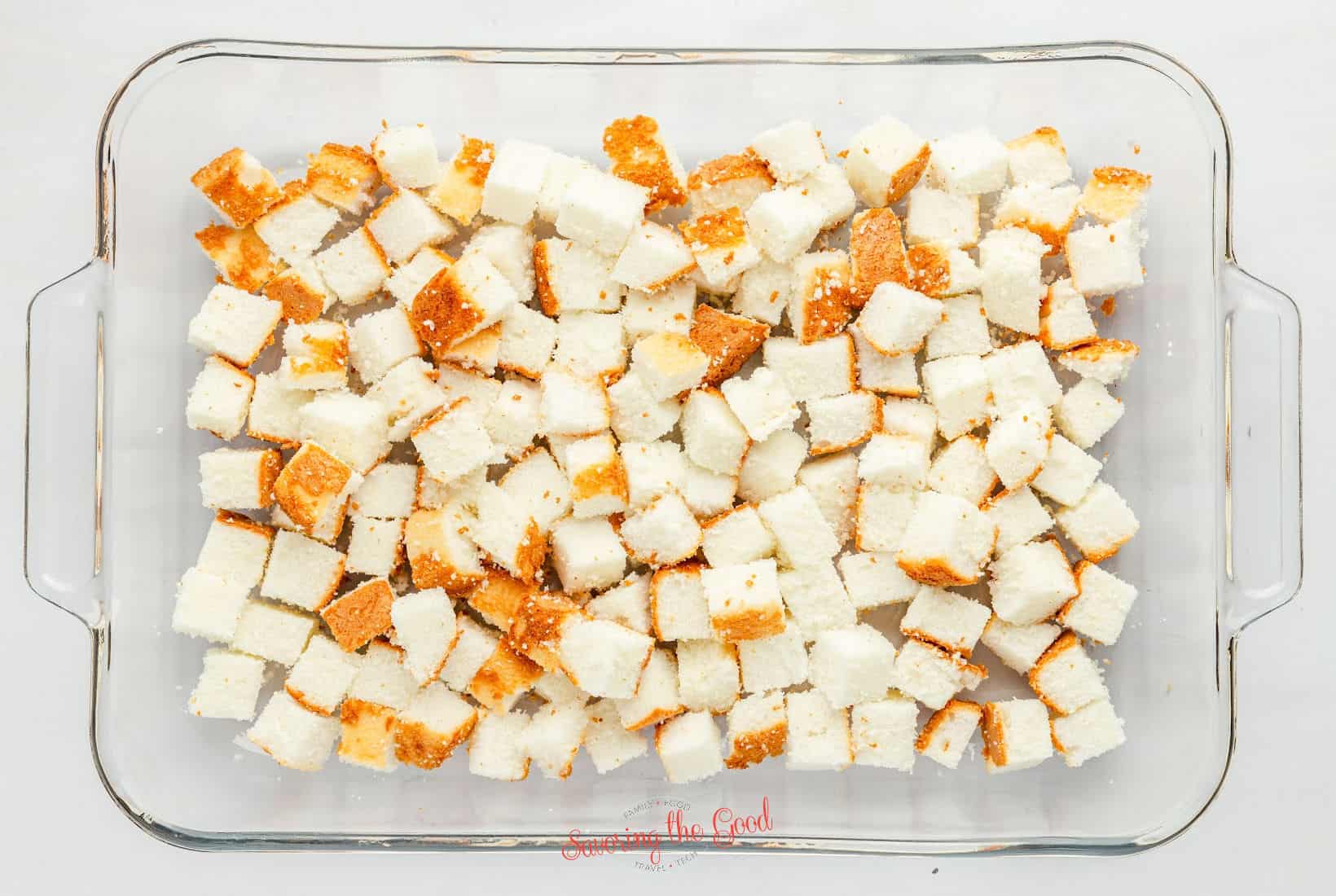 cubes of angel food cake in a glass pan.