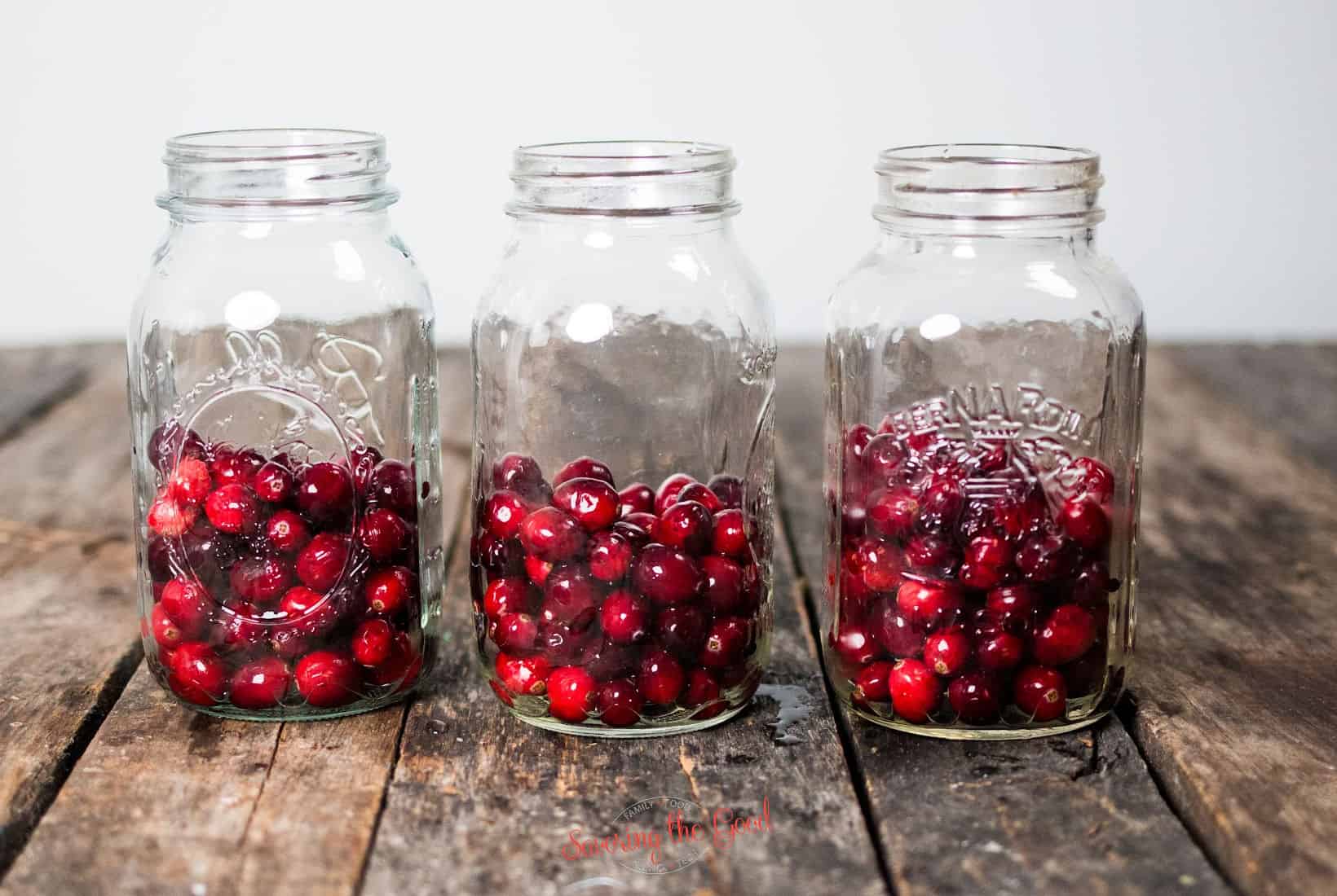 fresh, washed cranberries in quart jars.