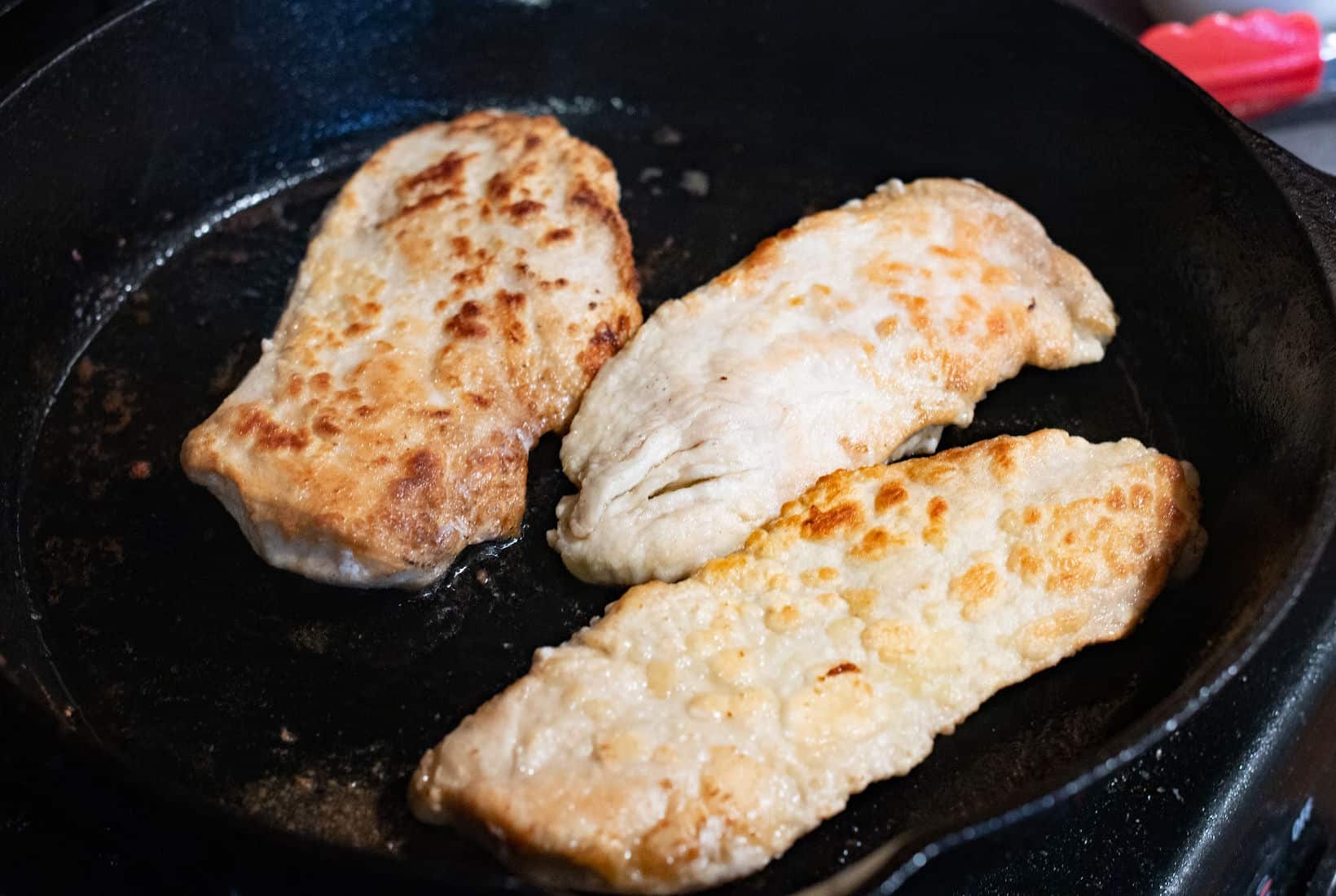 browned chciken breast in a cast iron pan.