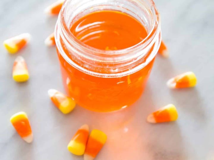 Homemade candy corn moonshine jar, featuring a delightful display of candy corns submerged in the infusion.