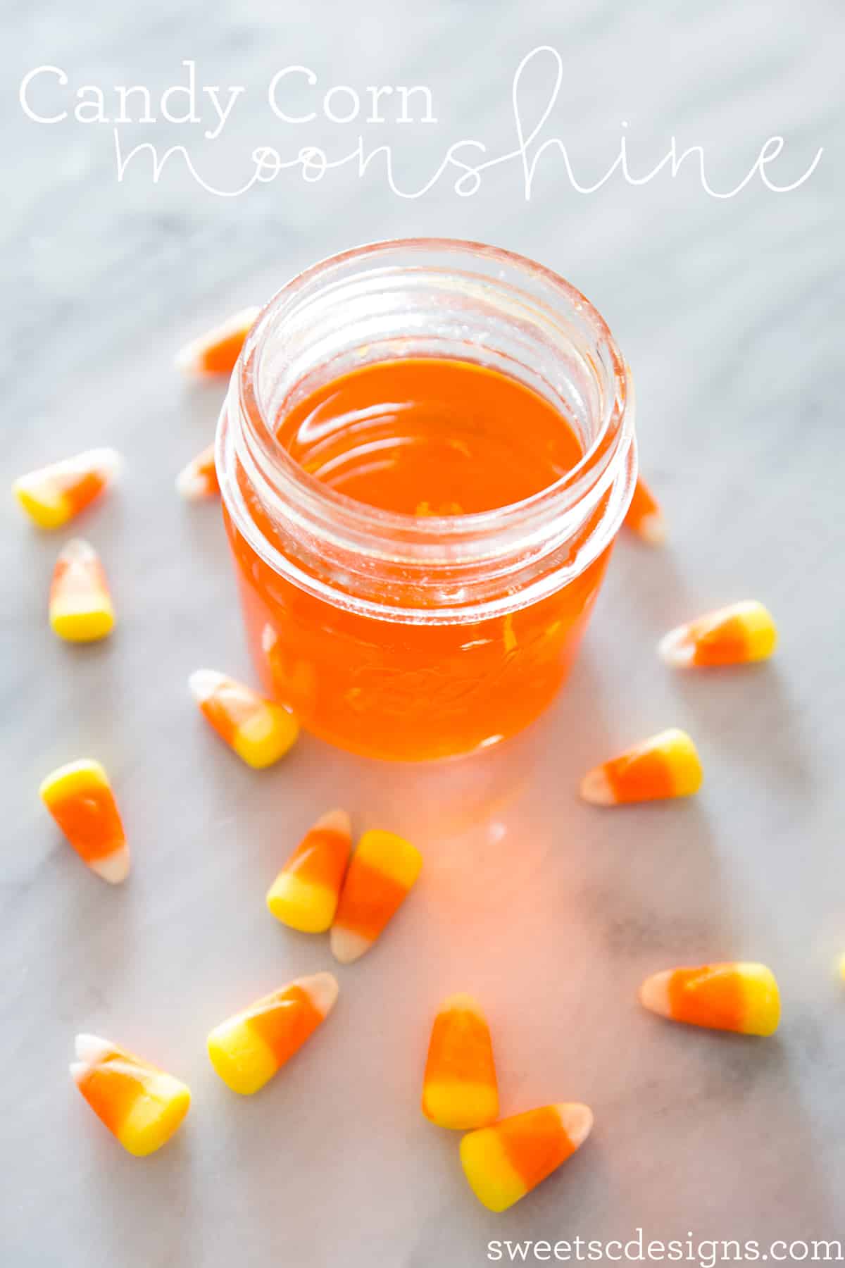 Homemade candy corn moonshine jar, featuring a delightful display of candy corns submerged in the infusion.