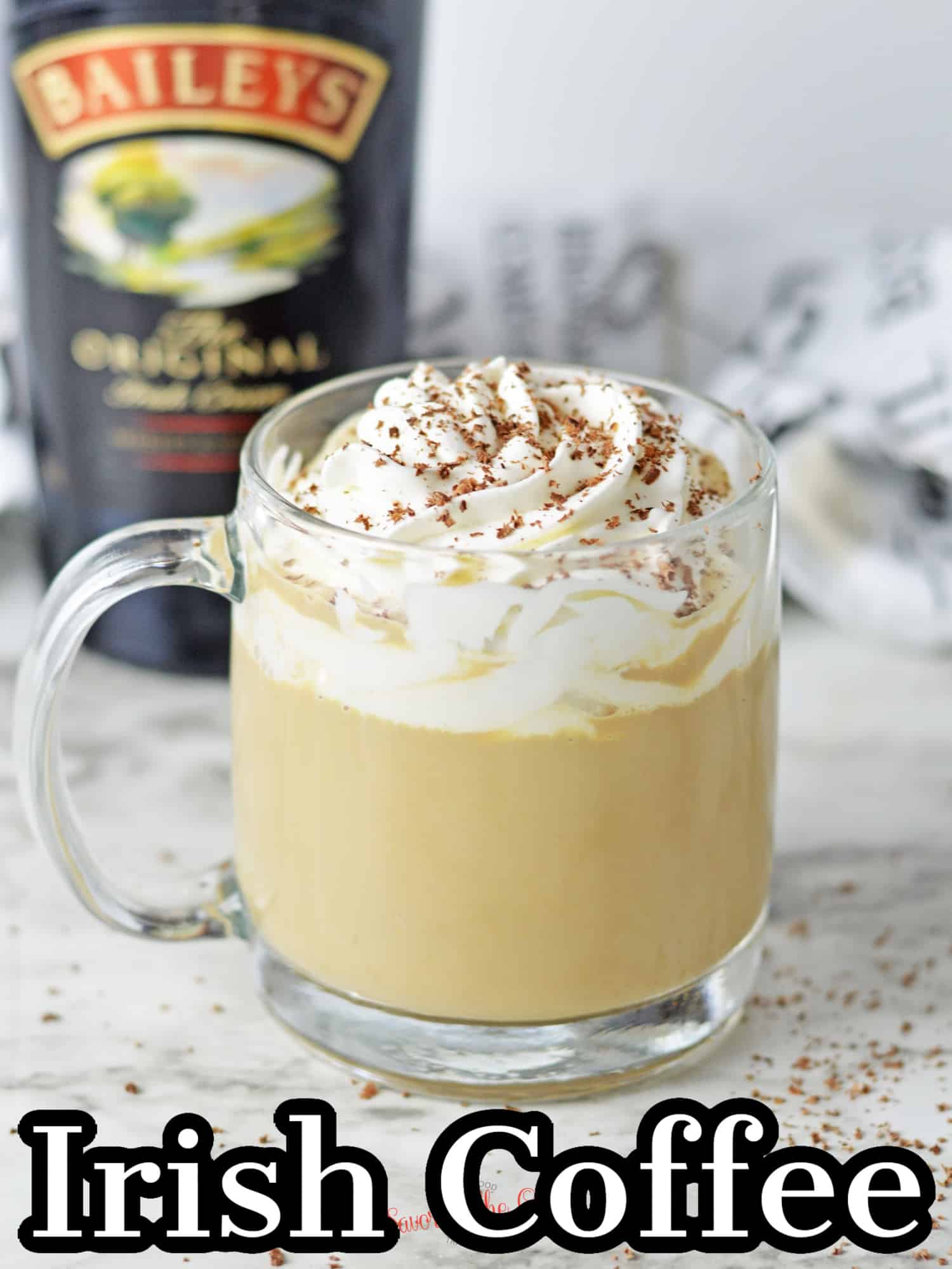 clear mug of baileys irish coffee with whipped cream and chocoalte shavings, text on the image for Pinterest.