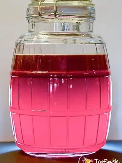 Easy Moonshine Recipes - A jar of pink liquid sitting on a table.