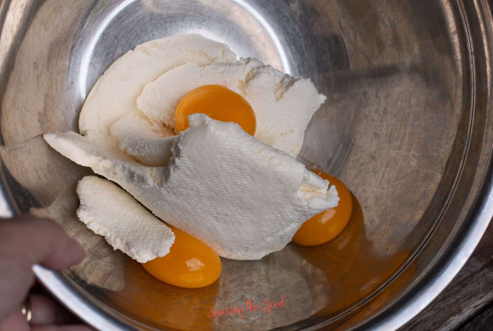 drained ricotta and 3 egg yolks in a stainless bowl.