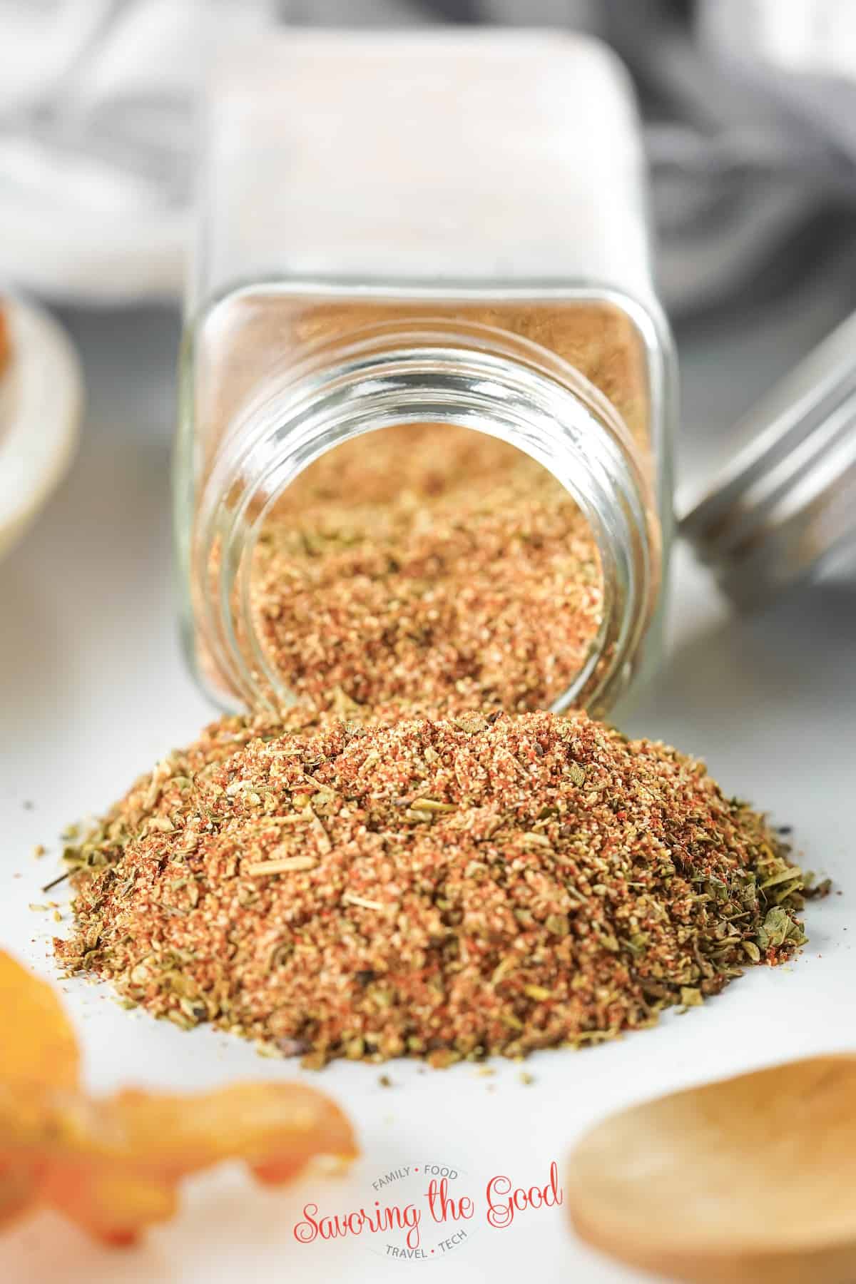 glass jar of All Purpose Seasoning tipped out on a surface in a pile.