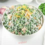english pea salad in a white bowl, square image.