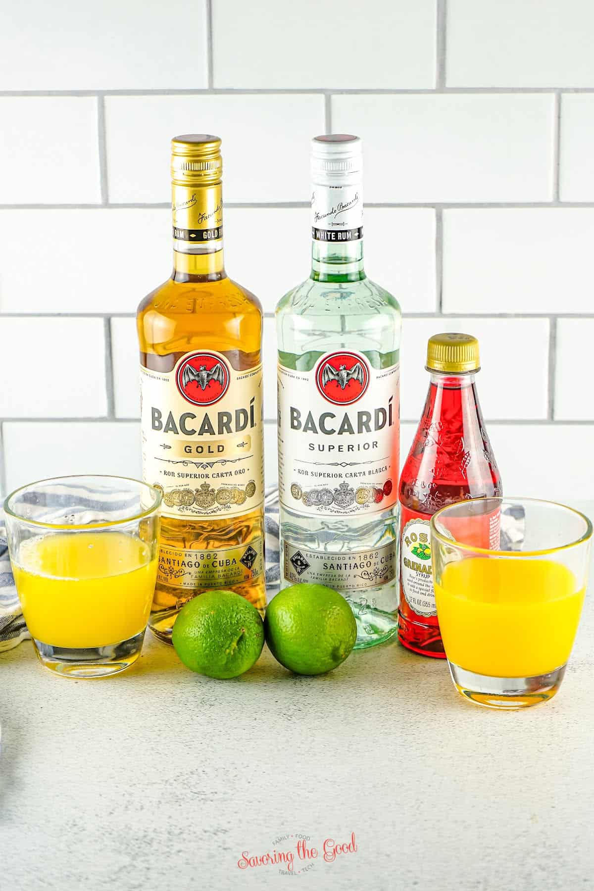 Jamaican rum punch ingredients, white rum, dark rum, orange juice, pineapple juice, lime, and grenadine.