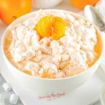 orange fluff salad in a white bowl, square image.
