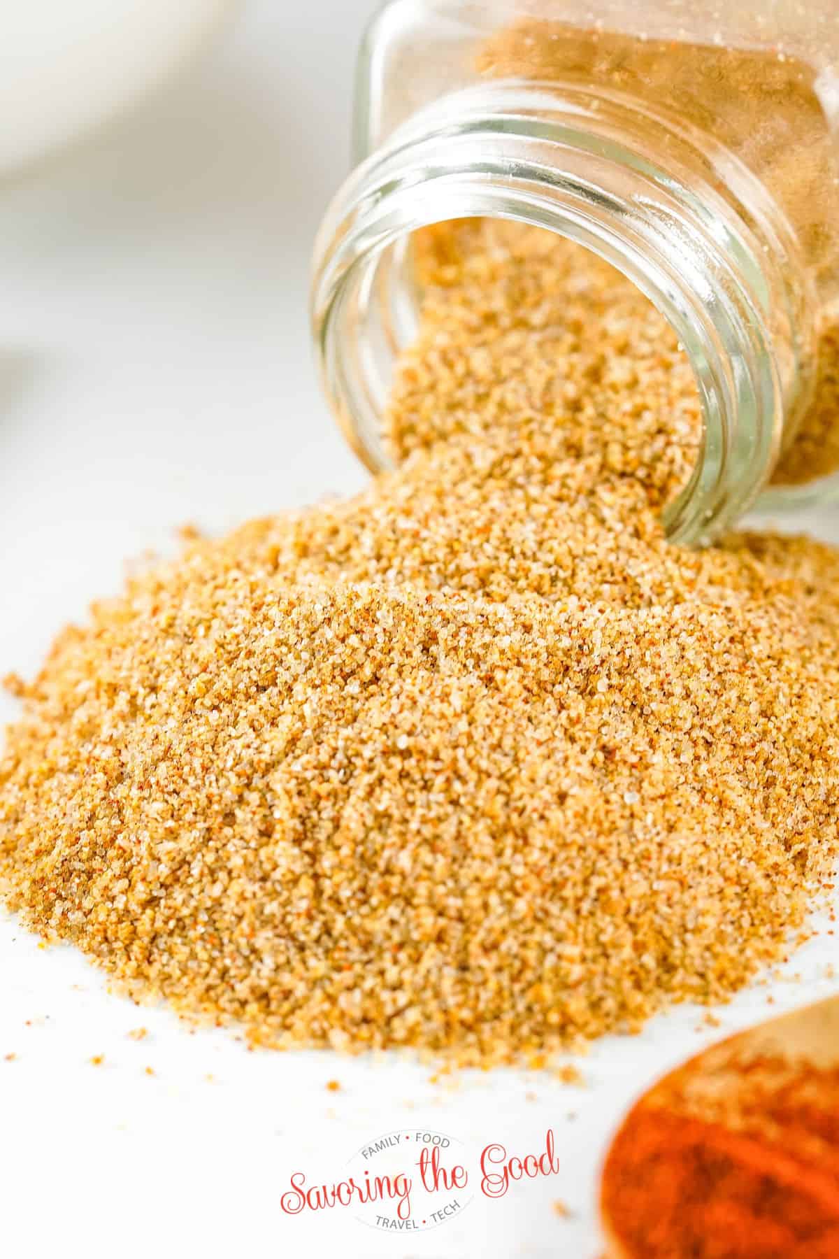 seasoned salt spilled out of a clear glass jar.