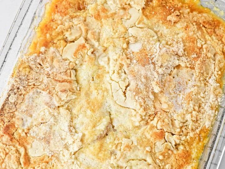 peach dump cake. square image. in a glass pan.