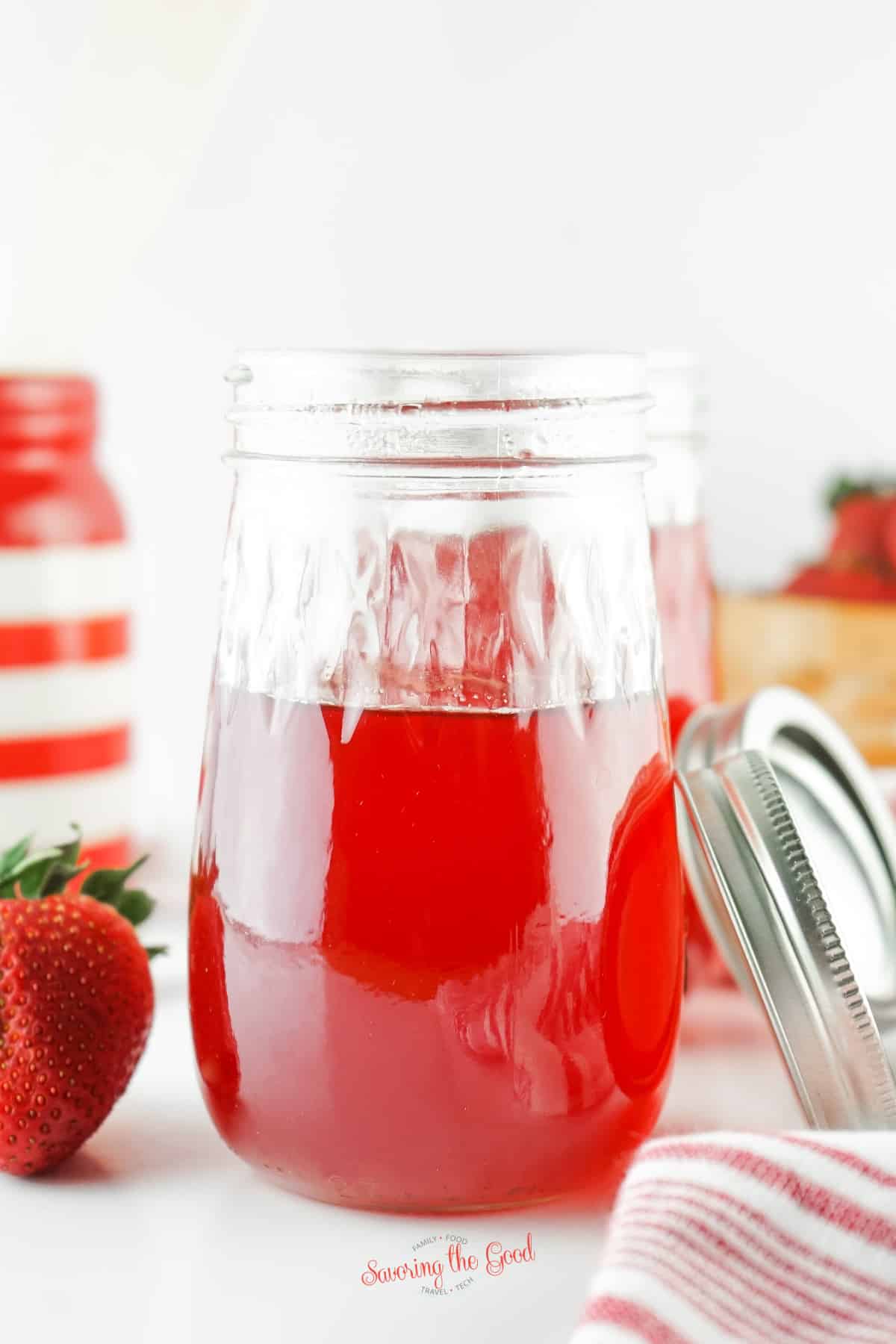 Strawberry Simple Syrup in a clear glass jar.