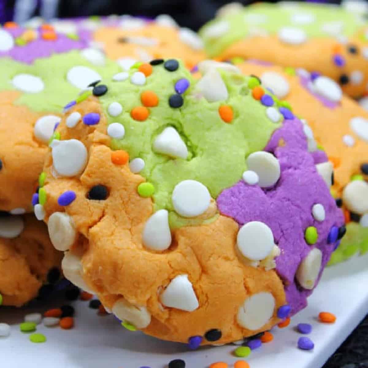 Halloween cookies with sprinkles on a white plate as the featured image of hocus pocus party food ideas.
