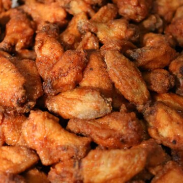 A close up of a pile of fried chicken wings.