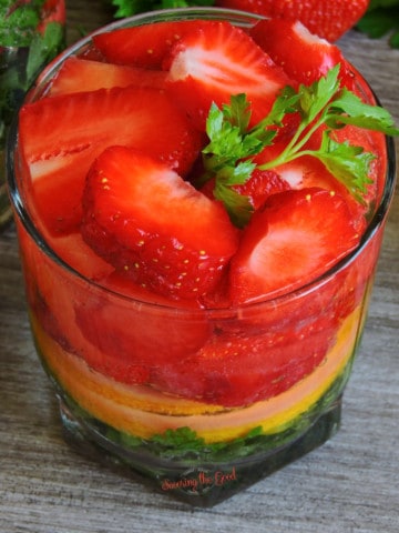 A glass filled with strawberries and mint for featured image for strawberry cocktails.