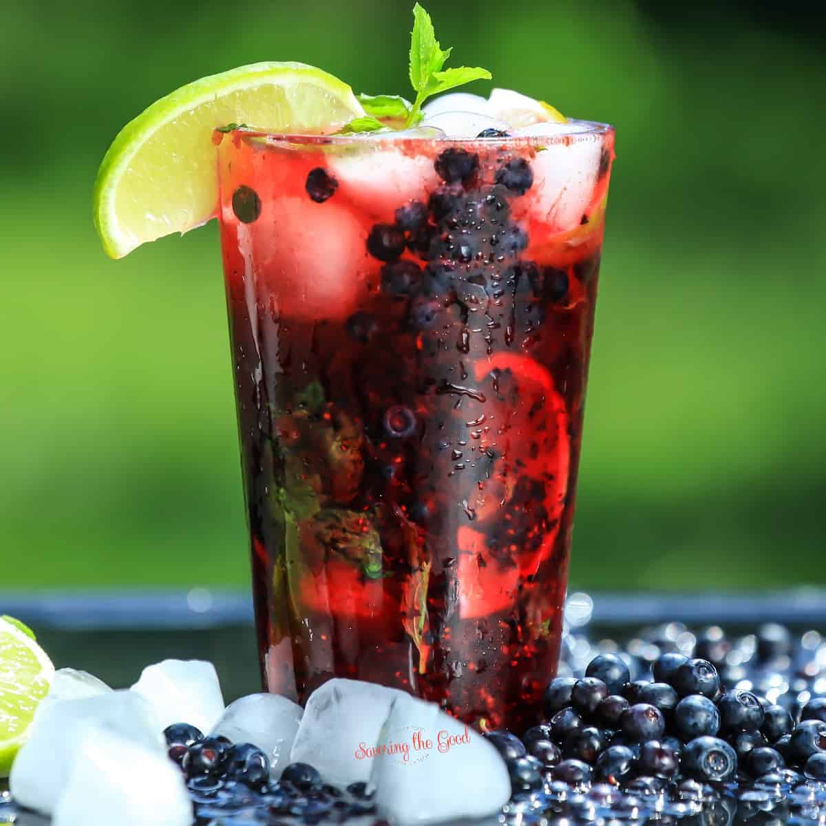 A blackberry mojito with lime and ice, perfect for blueberry cocktails.