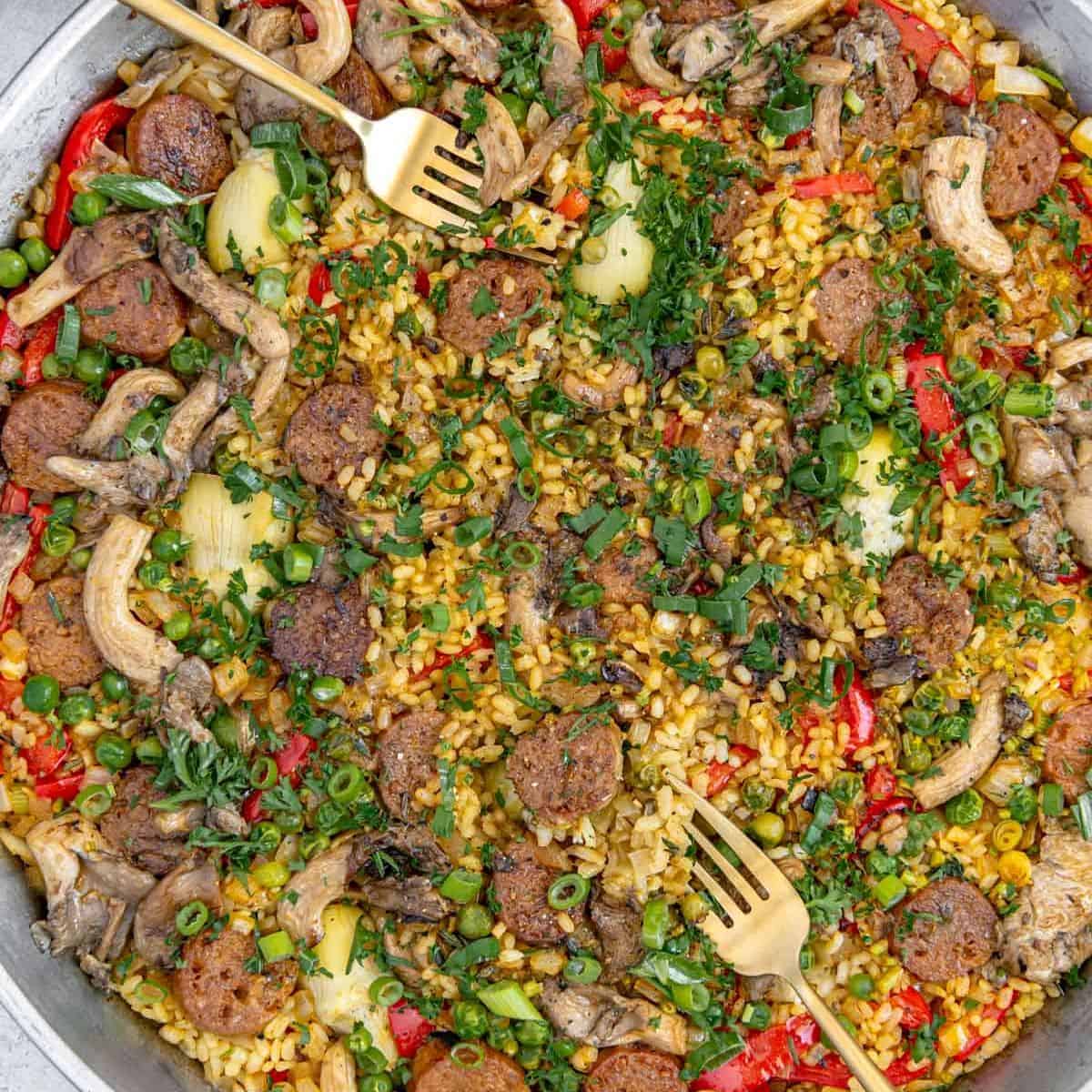 Paella with sausage and vegetables in a pan.