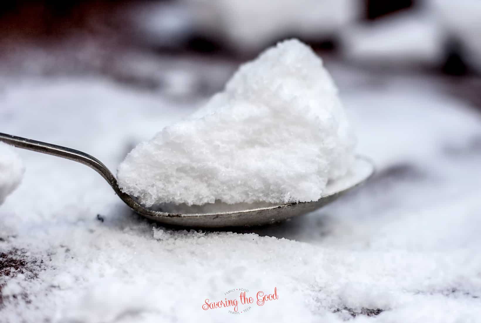 A spoonful of epsom salt on top of a pile of snow.
